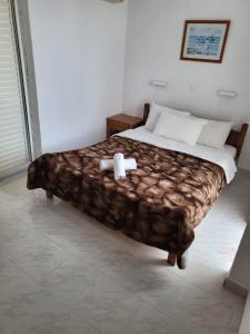 a bedroom with a bed with a teddy bear on it at Mertonas Studios in Karpathos