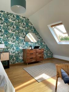 a attic bedroom with a skylight and a dresser at Maison familiale 11 couchages, proche de La Palue in Crozon