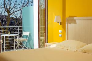 a bedroom with a bed and a balcony with a chair at De Maria House in SantʼAgata sui Due Golfi