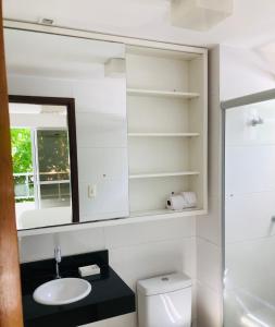 a bathroom with a sink and a mirror and a toilet at Tambaú Home Beira Mar - com varanda in João Pessoa
