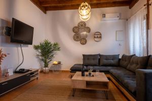 een woonkamer met een bank en een tv bij WALNUT TREE VILLA in Archanes