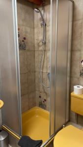 a shower with a yellow tub in a bathroom at Pension zur Hammermühle in Wallenfels