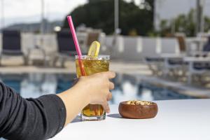 a person holding a drink and a bowl of nuts at Bodrum Vera Hotel in Bodrum City