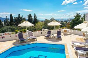 a swimming pool with chairs and umbrellas on a building at Bodrum Vera Hotel in Bodrum City