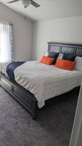 1 dormitorio con 1 cama con almohadas de color naranja y azul en Relax In a Beautiful New Home en Fountain