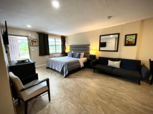 a bedroom with a bed and a couch in a room at Sheridan Suites Apartments in Dania Beach