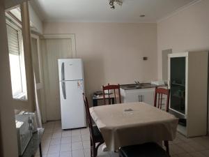 a kitchen with a table and a white refrigerator at Departamento al frente- Habitación con living in Tandil +5 photos