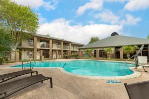 una piscina con 2 bancos frente a un edificio en Best Western Mcallen Medical Center, en McAllen