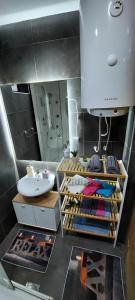 een badkamer met een wastafel, een toilet en een spiegel bij Family Apartment in Niš