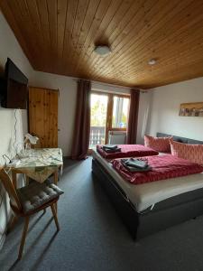 a bedroom with a large bed and a wooden ceiling at Pension zur Hammermühle in Wallenfels