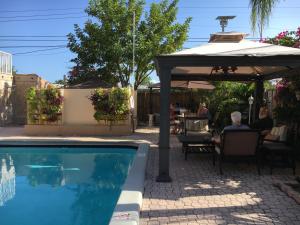 uma piscina com guarda-sol e pessoas sentadas à mesa em Sheridan Guesthouse em Dania Beach