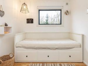 a white bed in a room with a window at Holiday home Roslev IX in Roslev