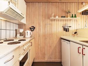 Nørre VorupørにあるSerene HolidayHome in Thisted near Seaの白い家電製品と木製の壁が備わるキッチン