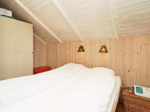 a bedroom with a bed and two lights on the wall at Holiday Home Dyssestræde in Dannemare