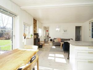 een keuken en een woonkamer met een houten tafel bij 6 person holiday home in Vejby in Vejby