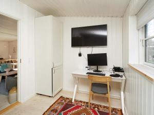 Habitación con escritorio y ordenador en la pared. en 6 person holiday home in Vejby, en Vejby