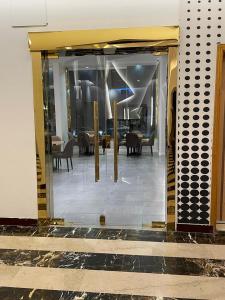 ターイフにあるالسهم الذهبي للشقق المخدومةの食堂付きの建物のガラス戸