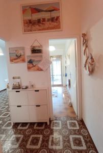 Cette chambre dispose d'une commode blanche et d'un couloir. dans l'établissement Le Palme 98 "Casa Vacanze", à Lido di Camaiore
