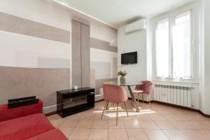 salon z czerwoną kanapą i stołem w obiekcie Exquisite Stay Vannucci- Porta Romana w Mediolanie