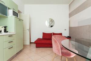 salon ze stołem i czerwoną kanapą w obiekcie Exquisite Stay Vannucci- Porta Romana w Mediolanie