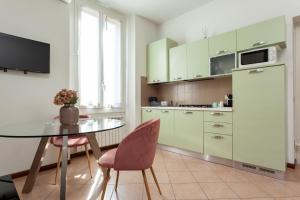 kuchnia ze stołem, krzesłami i lodówką w obiekcie Exquisite Stay Vannucci- Porta Romana w Mediolanie