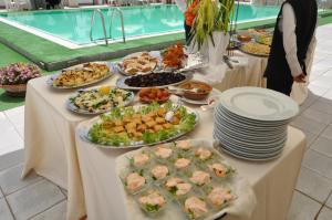 a buffet of food on a table with plates of food at Hotel Du Parc in Atri
