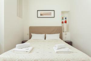 sypialnia z łóżkiem i dwoma białymi ręcznikami na nim w obiekcie Exquisite Stay Vannucci- Porta Romana w Mediolanie