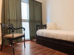 薩爾塔的住宿－Vicente López Premium，卧室配有床、椅子和窗户。