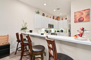 a kitchen with a bar with chairs and a counter top at Cristina's Tropical Villa/ Just minutes from Disney! in Kissimmee