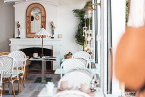 a living room with a fireplace and a table and chairs at Hôtel La Villa Juan Beach in Juan-les-Pins