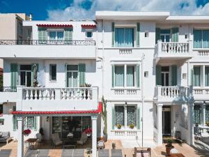 an apartment building with white facades and balconies at Hôtel La Villa Juan Beach in Juan-les-Pins