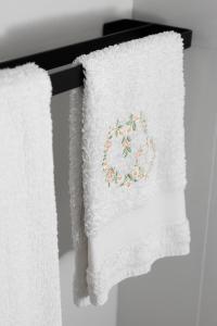 2 asciugamani sono appesi a un portasciugamani di Emperooms Guest House a Roma