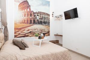 una camera con un letto e una foto del Colosseo di Emperooms Guest House a Roma