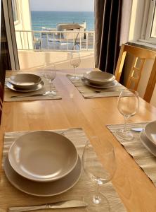 a table with plates and glasses on a table with a view at Ocean Breeze in Armação de Pêra