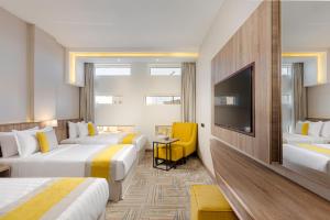 um quarto de hotel com duas camas e uma televisão de ecrã plano em The Seasons Hotel em Medina