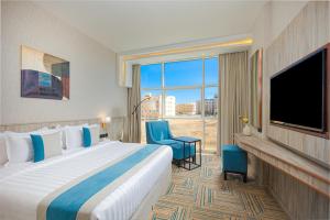 a hotel room with a large bed and a large window at The Seasons Hotel in Al Madinah