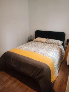 Un dormitorio con una cama con una manta amarilla. en Maison scandinave avec garage, en Roubaix