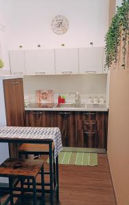 eine Küche mit weißen Schränken, einer Spüle und einem Tisch in der Unterkunft Suite Mirella in Neapel