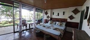 a bedroom with a bed and a large window at Eco Hotel Aldea -AMAZONAS in Puerto Nariño