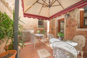 a patio with tables and chairs and an umbrella at Cà Valeri in Venice
