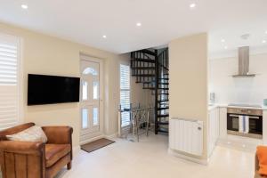- un salon avec une télévision, un canapé et une chaise dans l'établissement Bright 1 Bedroom Apartment Near Edgware Road, à Londres