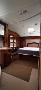 a bedroom with a bed and a desk in a boat at Vagabond Historic in Port Germein