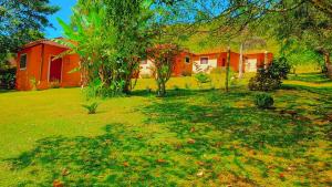 een oranje huis in een tuin met een boom bij Pousada Campestre Cunha-SP in Cunha