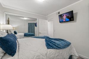een slaapkamer met een bed en een flatscreen-tv aan de muur bij Wake up to Ocean Views from your private balcony in Tampa