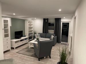 a living room with a couch and a tv at Haus Mariechen in Hooksiel