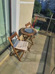 een tafel en 2 stoelen op een balkon met een tafel bij Seaside Family Apartment Faleza Nord in Constanţa
