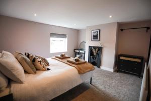 a bedroom with a bed with pillows and a fireplace at Auctioneers Cottage in Louth