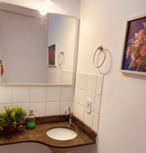 a bathroom with a sink and a mirror at Apart. Praia da Costa Premium in Vila Velha