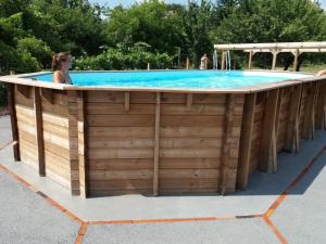 einen Pool mit einer Holzrückhaltewand und einem Holzzaun in der Unterkunft Gîte Le Champ-Saint-Père, 4 pièces, 8 personnes - FR-1-426-239 in Le Champ-Saint-Père