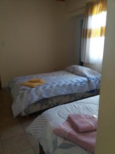 Dos camas en un dormitorio con toallas. en Departamento Mi casa en Mendoza en Godoy Cruz